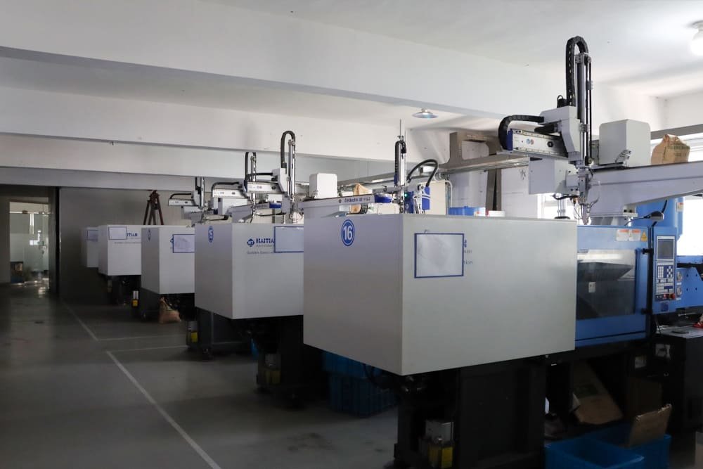 Row of Haitian injection molding machines with robotic arms in a plastic gear manufacturing facility