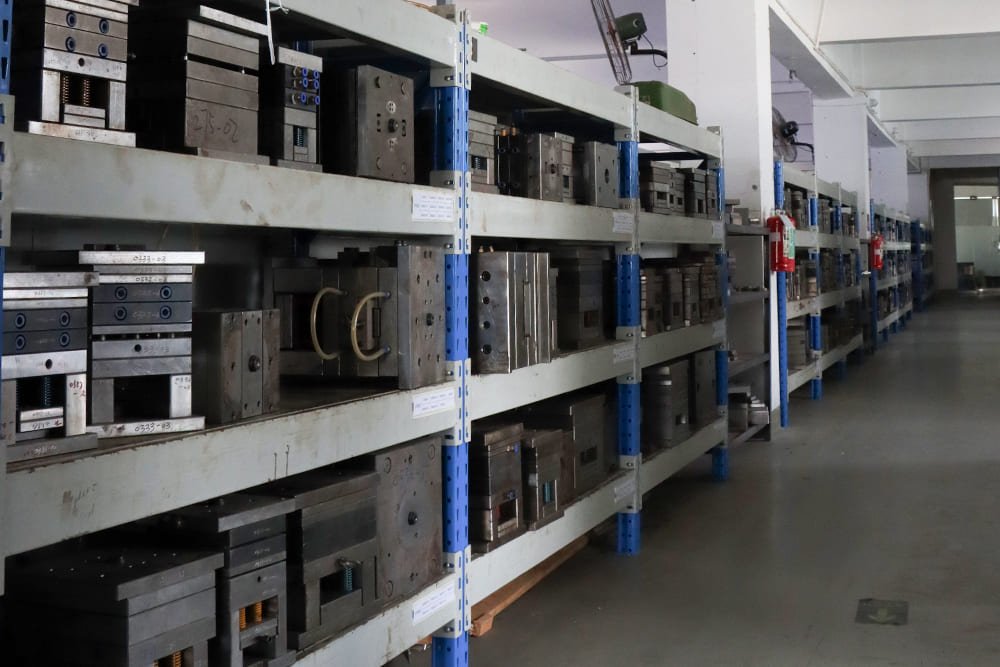 Steel injection molds stored on industrial shelving racks in a plastic gear mold library